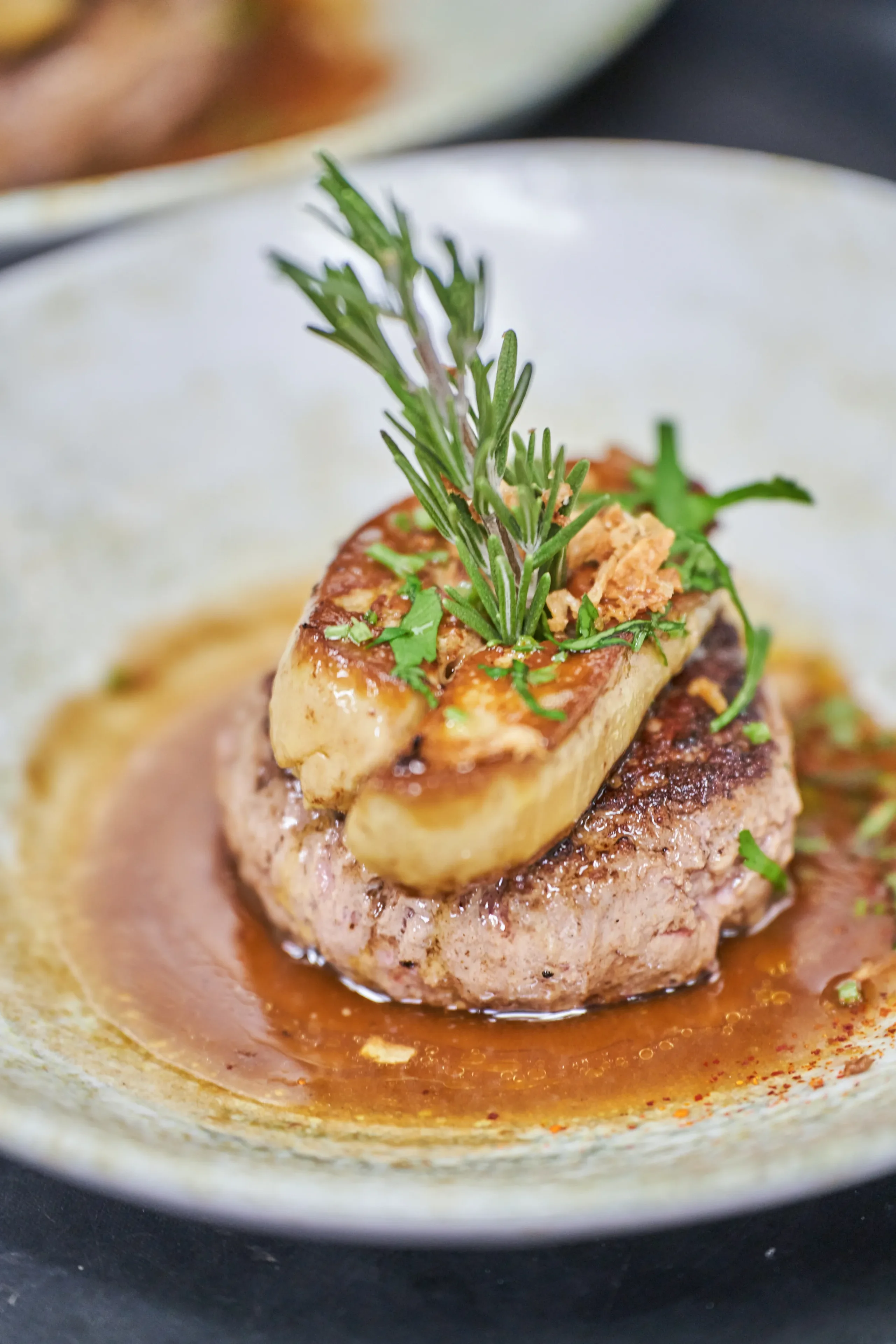 Plat de foie gras avec sauce et herbes.