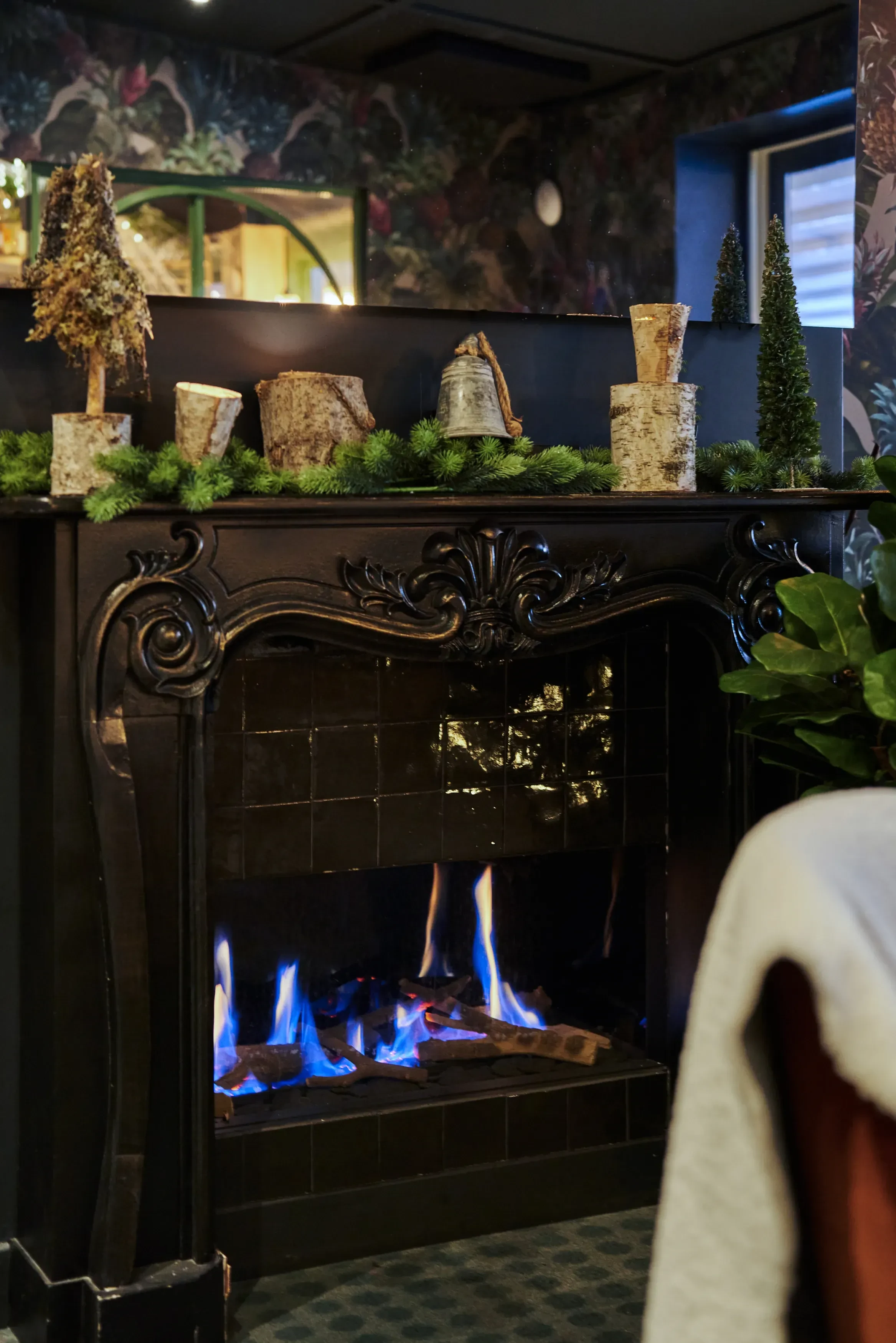 Cheminée décorée avec feu et bûches.