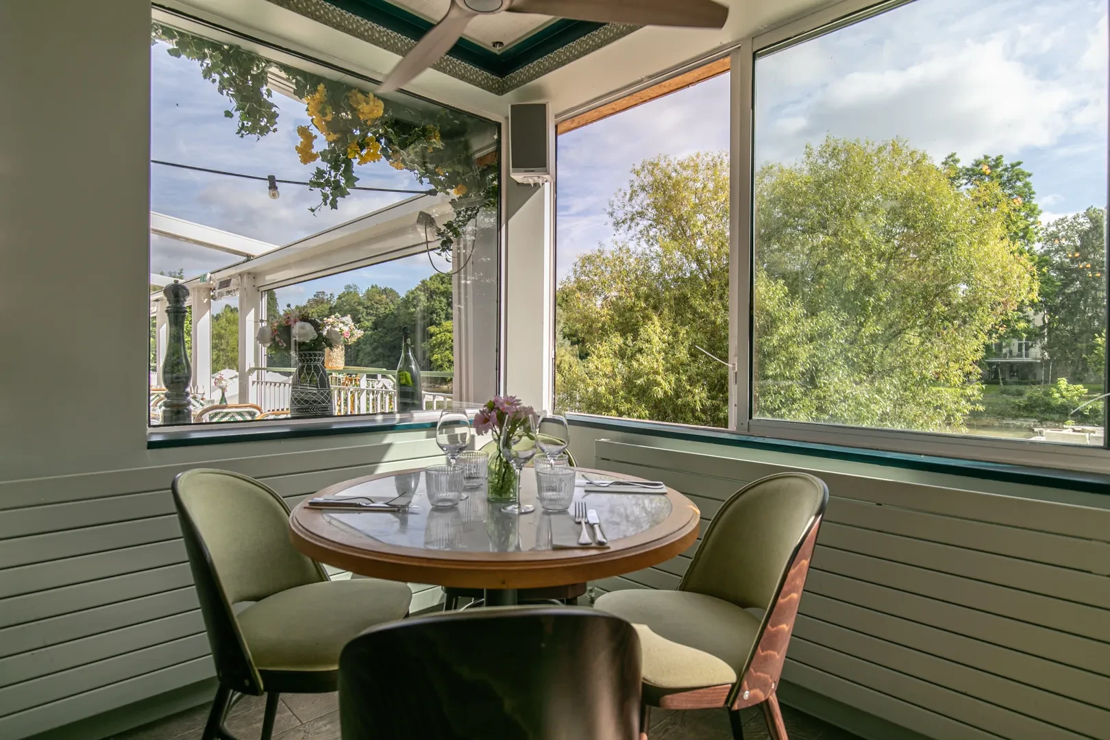 Table au restaurant avec vue sur jardin verdoyant.