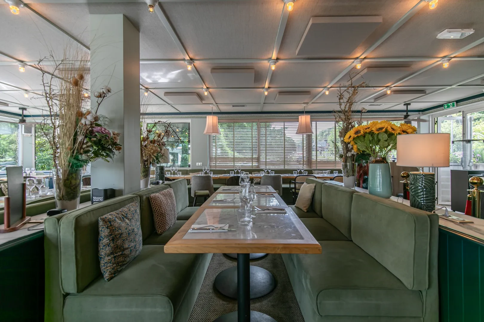 Intérieur d'un restaurant moderne avec tables et plantes.