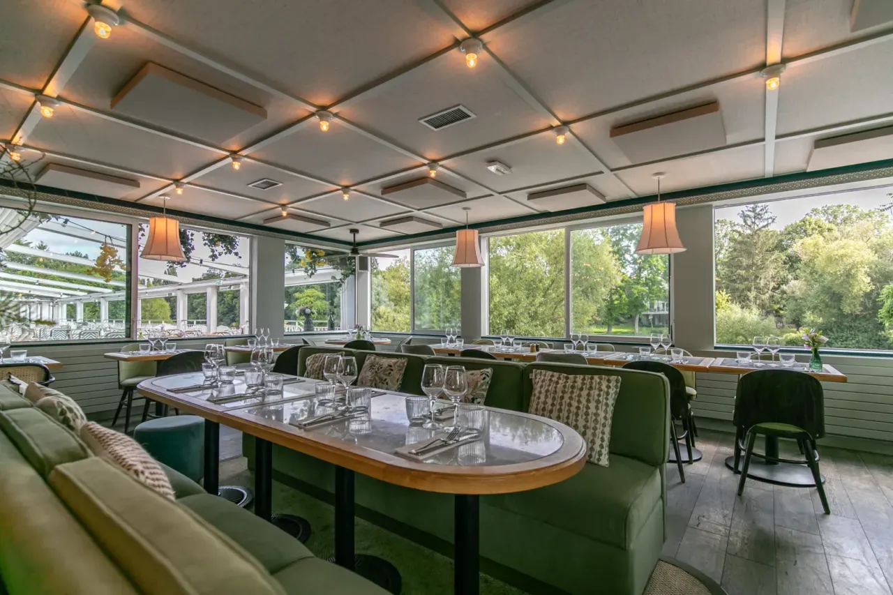 Intérieur d'un restaurant moderne avec vue sur jardin.