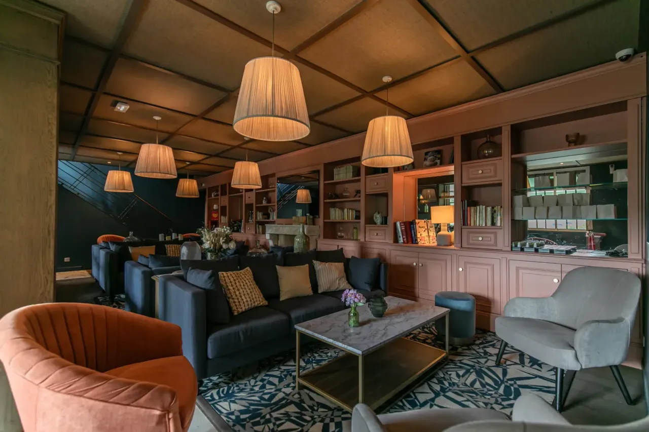 Salon élégant avec canapé gris et lampes suspendues.