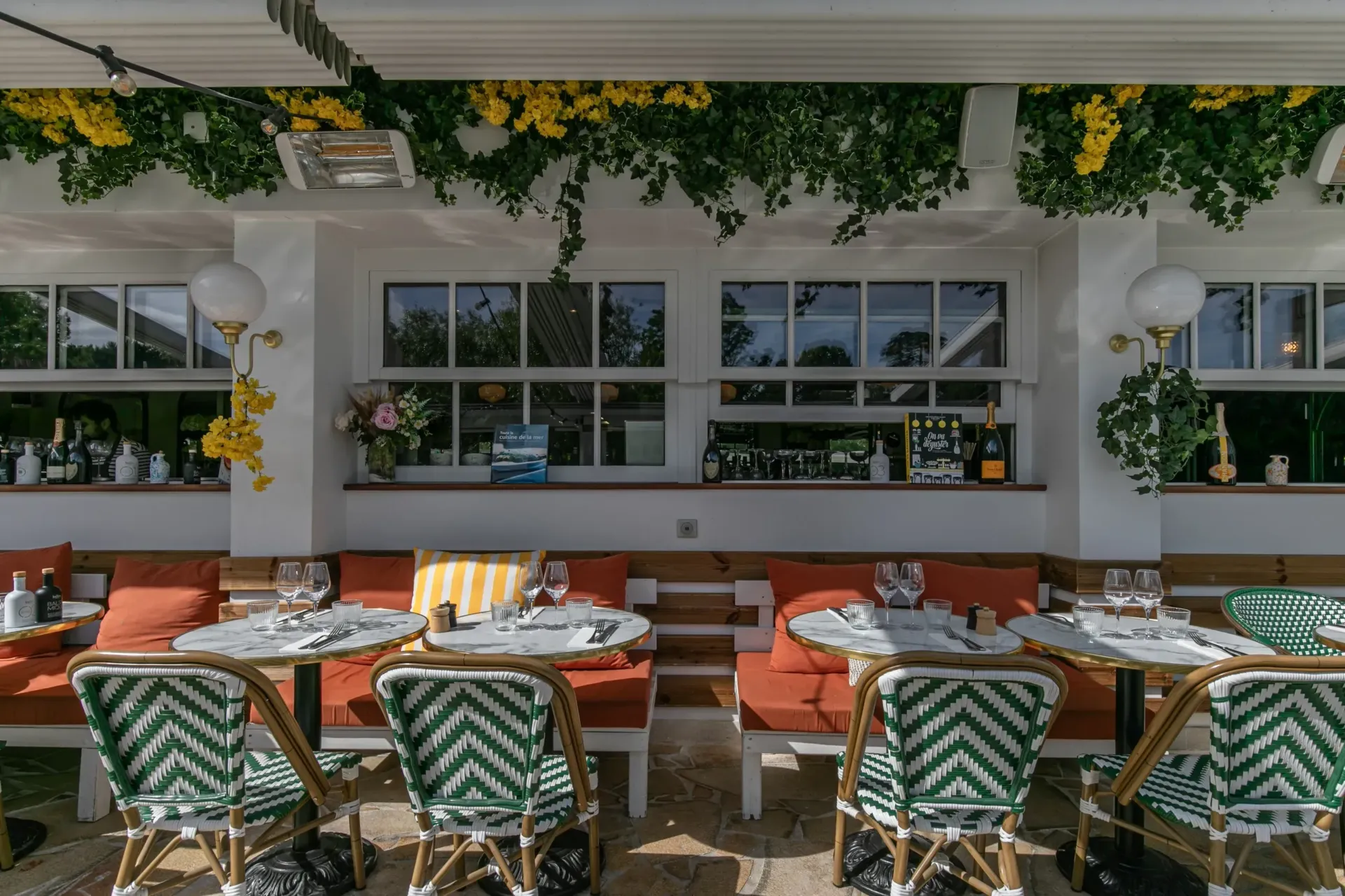 Terrasse de restaurant avec tables et chaises vides.